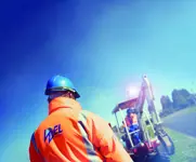 Workers in high-visibility clothing with a digger